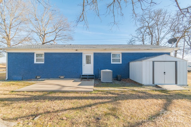 rear view of house featuring cooling unit, a storage shed, a yard, and a patio area