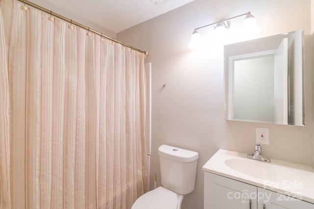 bathroom with vanity, curtained shower, a textured ceiling, and toilet