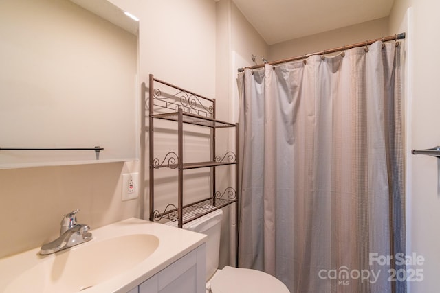 bathroom featuring vanity, toilet, and walk in shower