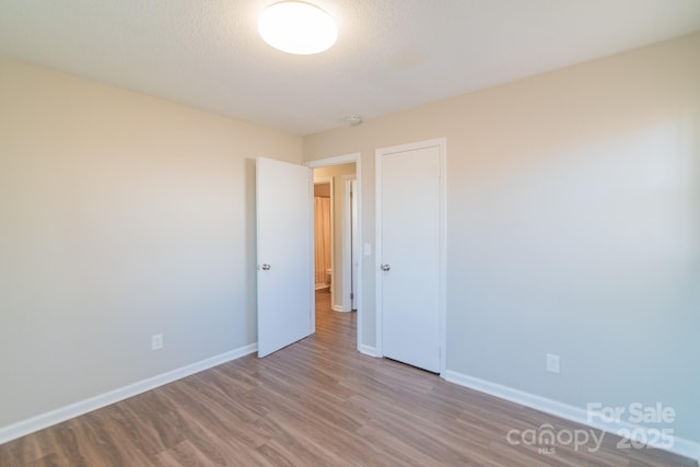 empty room featuring hardwood / wood-style flooring and a textured ceiling