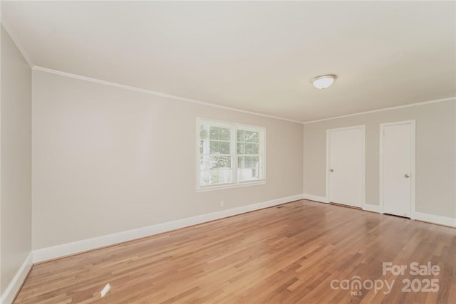 spare room featuring ornamental molding and light wood-type flooring