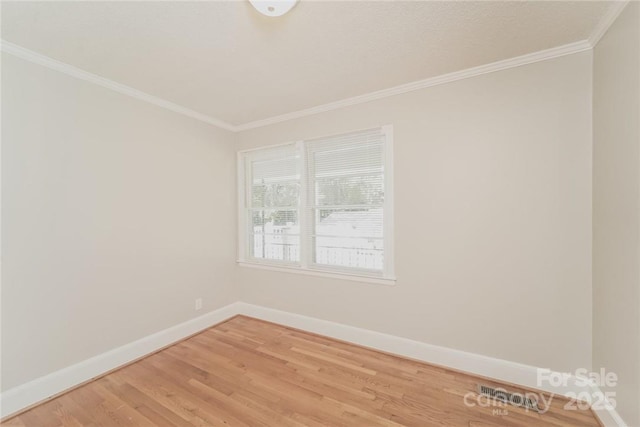 empty room with hardwood / wood-style flooring and ornamental molding