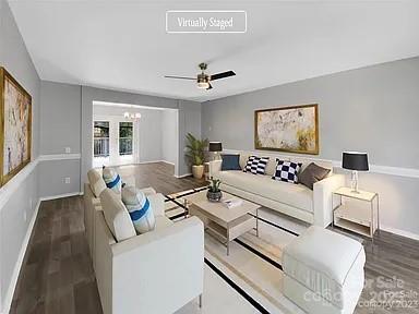 living room with dark hardwood / wood-style floors and ceiling fan with notable chandelier