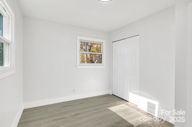 unfurnished bedroom with dark wood-type flooring and a closet