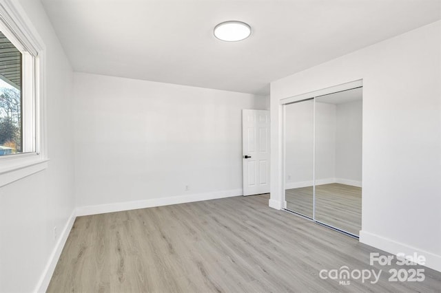 unfurnished bedroom featuring light wood-type flooring and a closet