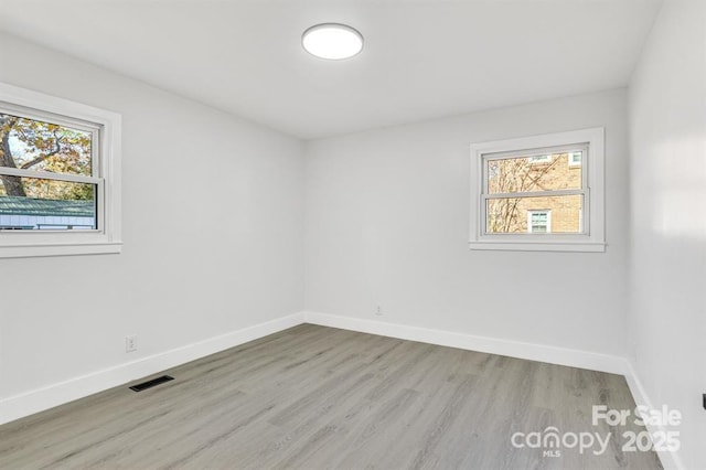 spare room featuring light hardwood / wood-style flooring and a wealth of natural light