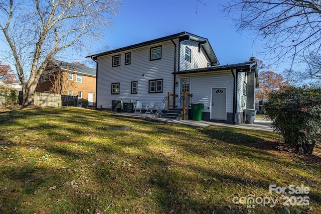 rear view of property featuring central AC unit and a yard