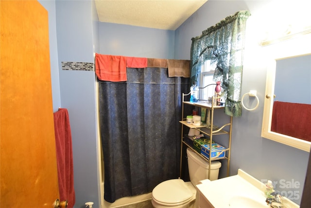 bathroom featuring vanity, curtained shower, a textured ceiling, and toilet