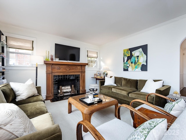 living room with a tile fireplace and ornamental molding