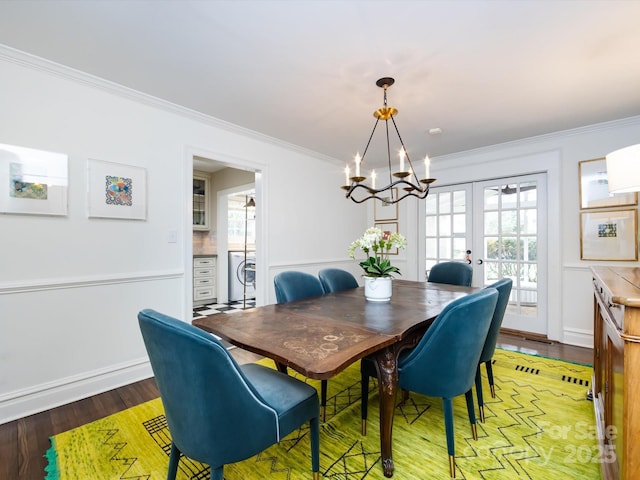 dining room with crown molding, wood-type flooring, washer / dryer, and french doors