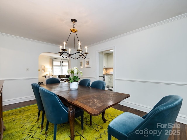 dining room with crown molding, dark hardwood / wood-style floors, and a notable chandelier