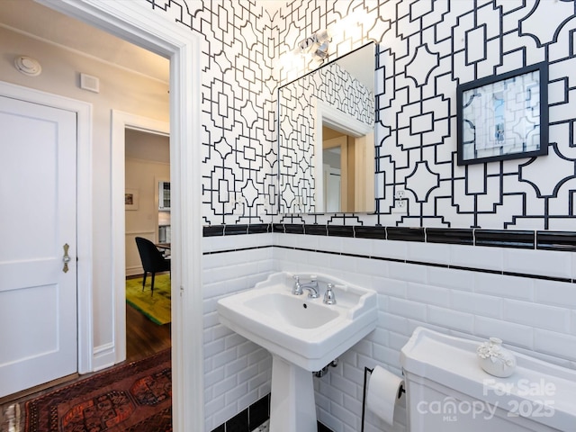 bathroom with tile walls, sink, and toilet