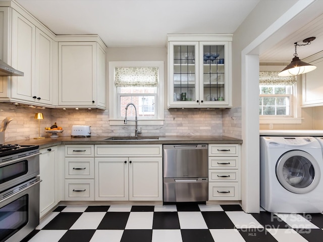 kitchen featuring sink, washer / dryer, a wealth of natural light, and appliances with stainless steel finishes