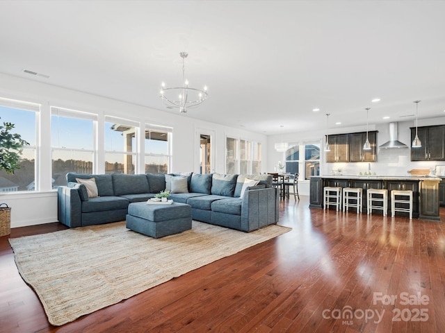 living room with dark wood-type flooring, sink, and an inviting chandelier