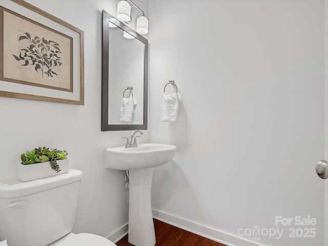 bathroom featuring wood-type flooring, sink, and toilet