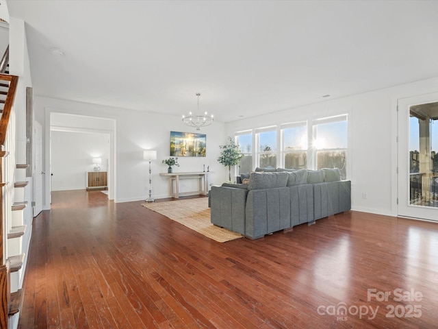 unfurnished living room with hardwood / wood-style flooring and a chandelier