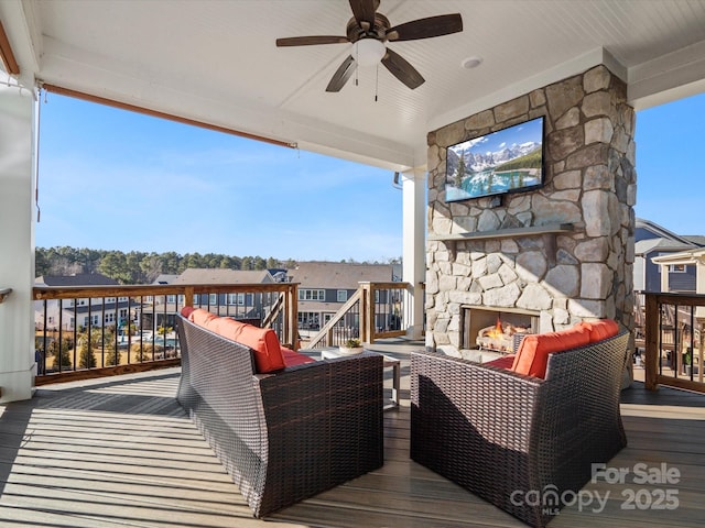 deck featuring an outdoor living space with a fireplace and ceiling fan