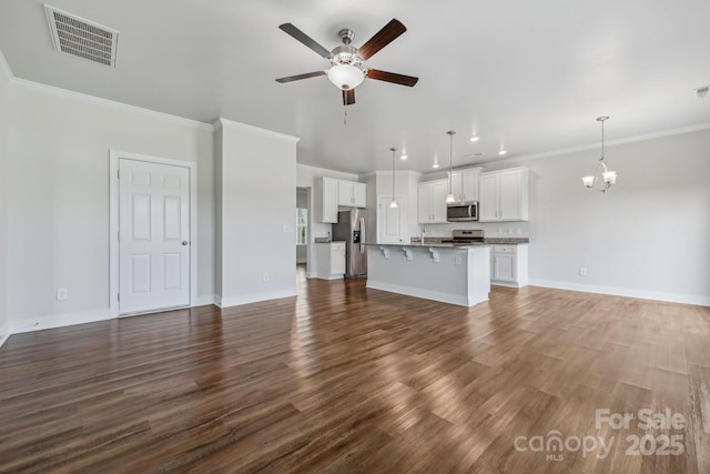 unfurnished living room with ornamental molding, dark hardwood / wood-style floors, and ceiling fan with notable chandelier