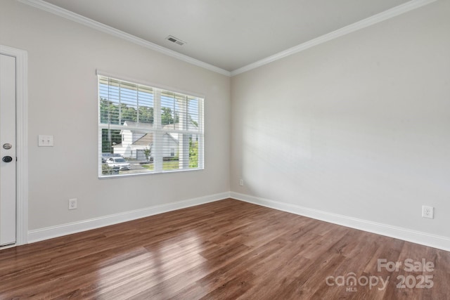 empty room with ornamental molding and wood-type flooring