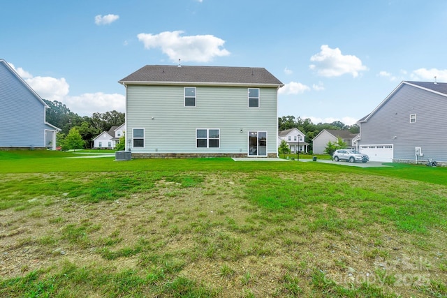 rear view of property with a garage, central air condition unit, and a lawn