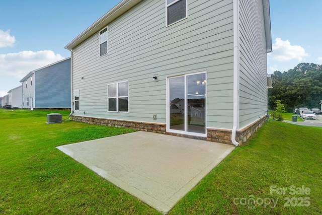 rear view of house with a patio, central air condition unit, and a lawn