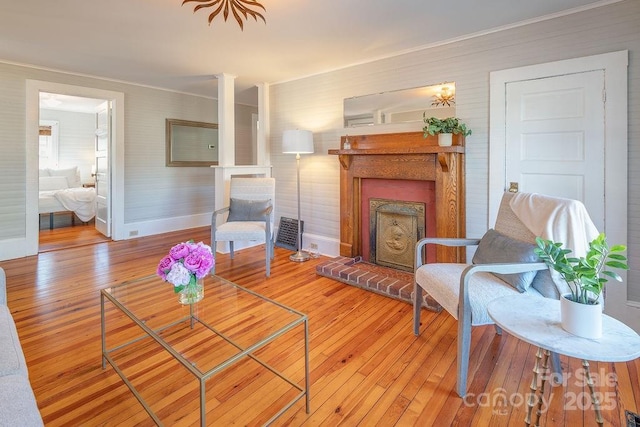 living area featuring a fireplace, baseboards, and hardwood / wood-style floors