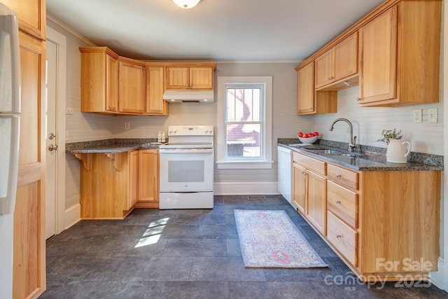 kitchen with dark stone counters, white appliances, a sink, and under cabinet range hood