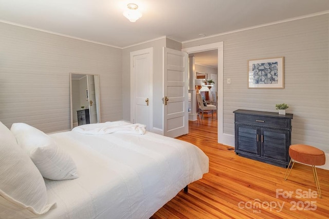 bedroom featuring ornamental molding and light wood-type flooring