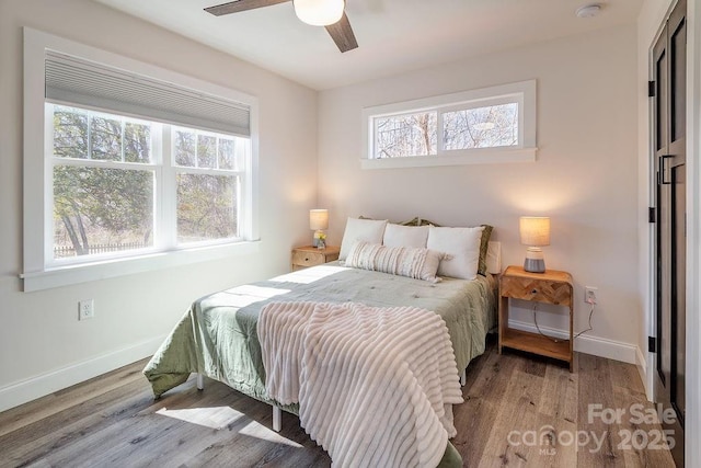 bedroom featuring a ceiling fan, baseboards, and wood finished floors