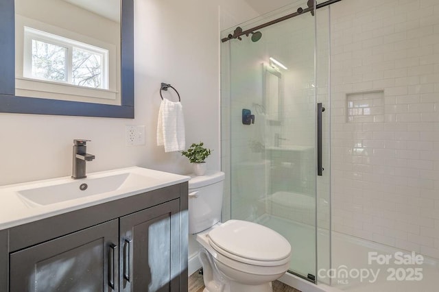 full bath with vanity, a shower stall, and toilet