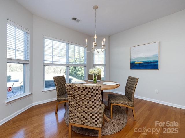 dining space with a notable chandelier, visible vents, plenty of natural light, and wood finished floors