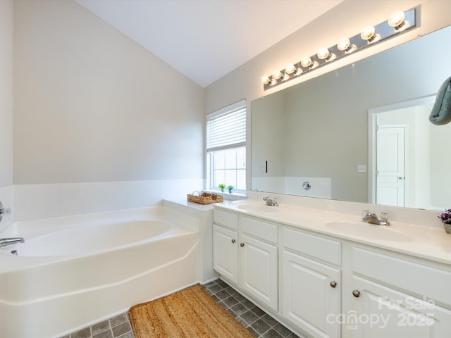 bathroom with a bath, tile patterned flooring, double vanity, and a sink