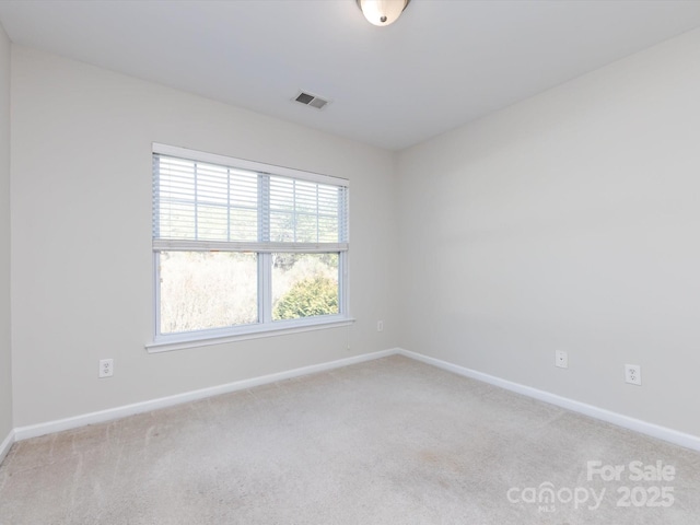 unfurnished room with light carpet, visible vents, and baseboards