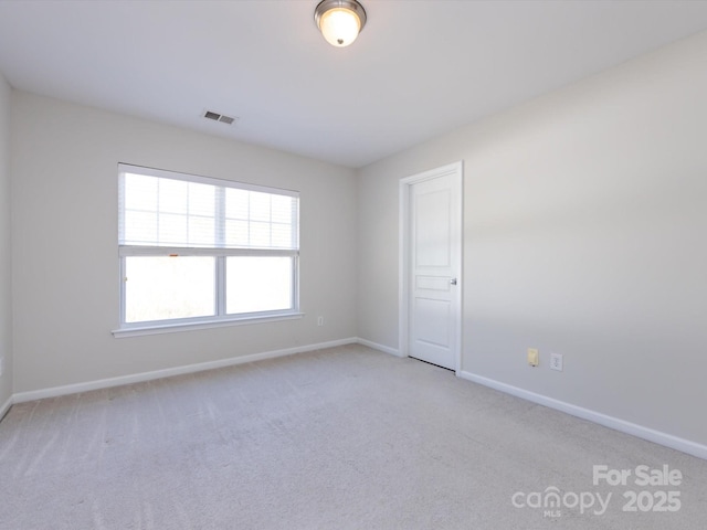 empty room with visible vents, baseboards, and carpet floors