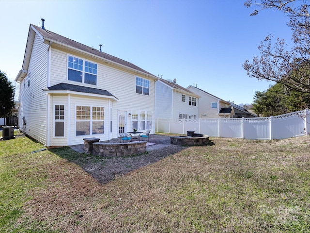 rear view of property with a fenced backyard, a patio, an outdoor fire pit, and a yard