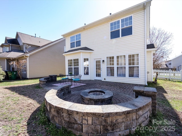 back of property featuring a fire pit, a patio, and fence