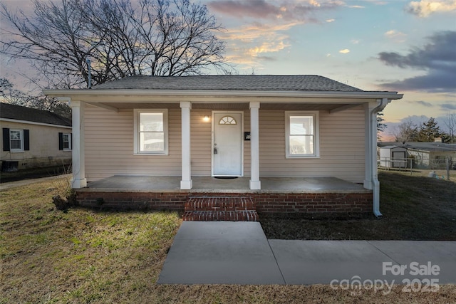 bungalow-style home featuring a yard and covered porch