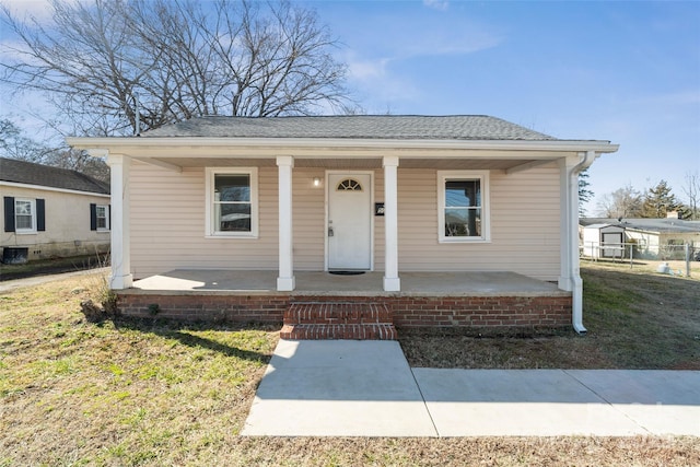 bungalow-style house with a front yard and covered porch