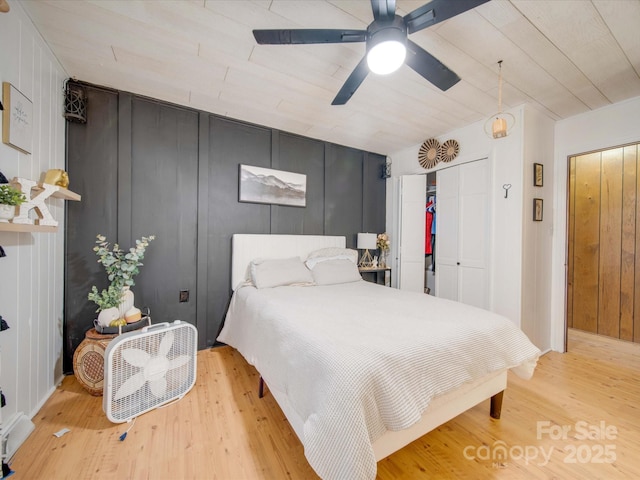 bedroom featuring ceiling fan, a closet, and light wood-type flooring