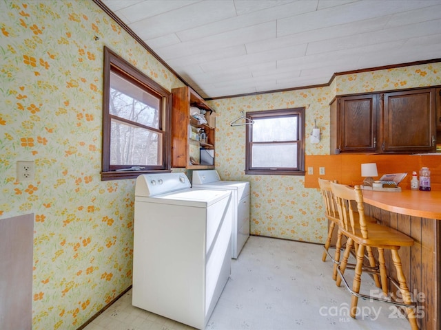 laundry room with cabinets, washing machine and clothes dryer, and crown molding