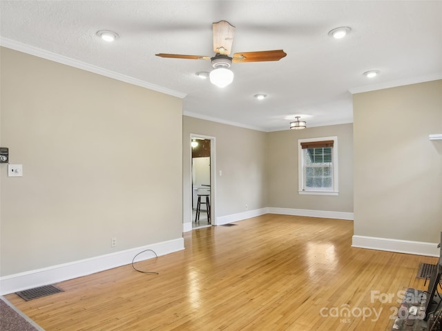 spare room with ceiling fan, ornamental molding, and light hardwood / wood-style flooring