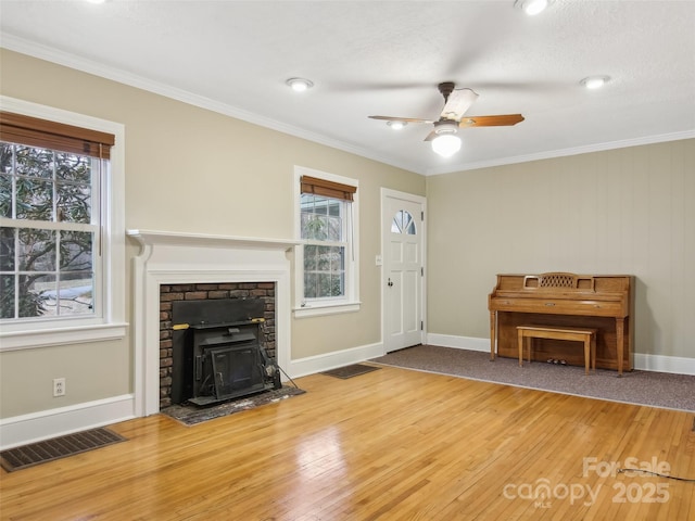 unfurnished living room with hardwood / wood-style floors, crown molding, and ceiling fan