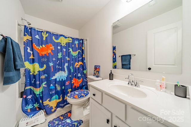 bathroom with tile patterned flooring, vanity, and toilet