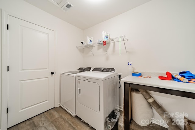 laundry room with hardwood / wood-style flooring and washer and clothes dryer