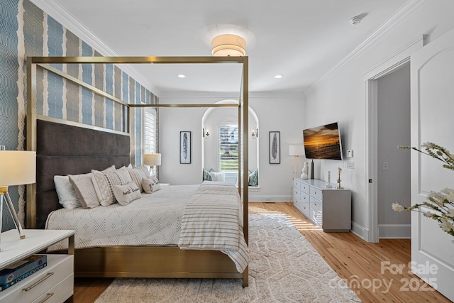 bedroom featuring ornamental molding, light wood-type flooring, and baseboards