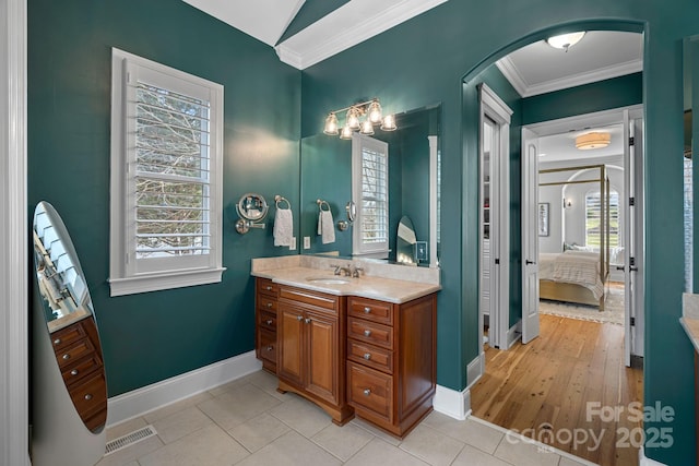 ensuite bathroom with ornamental molding, a wealth of natural light, visible vents, and ensuite bathroom