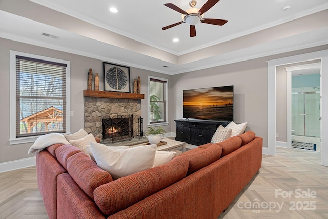 living area with a healthy amount of sunlight, a fireplace, visible vents, and baseboards