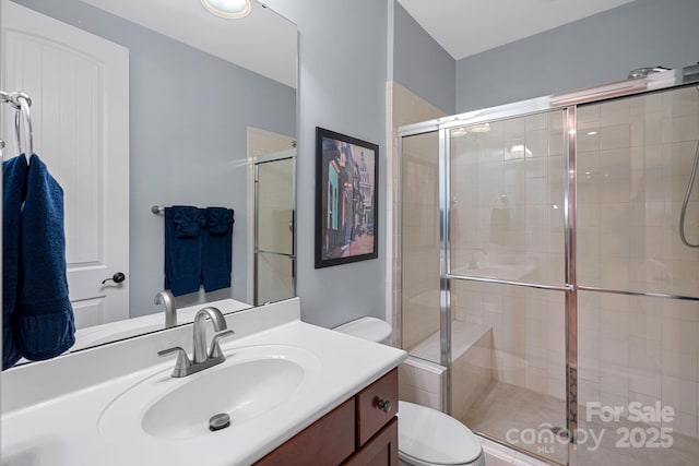 full bathroom with a shower stall, toilet, and vanity