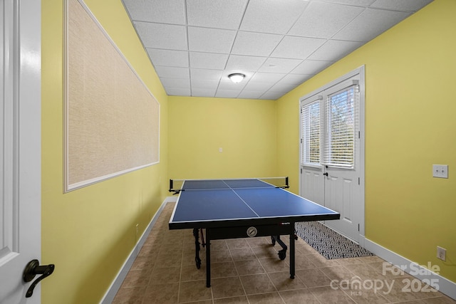 playroom with tile patterned flooring, a drop ceiling, and baseboards