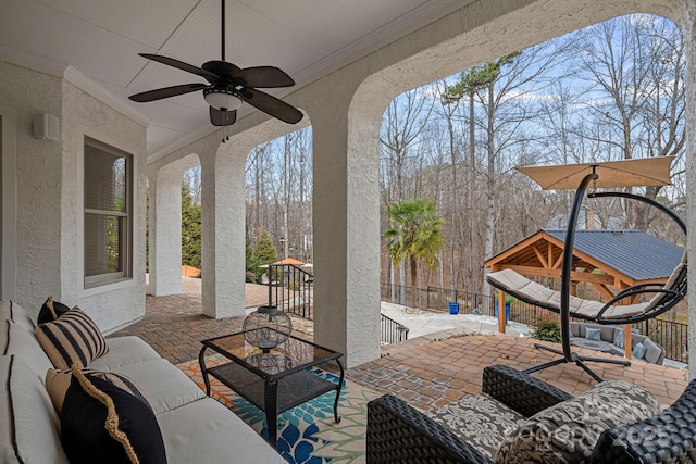 view of patio featuring ceiling fan, an outdoor hangout area, and fence